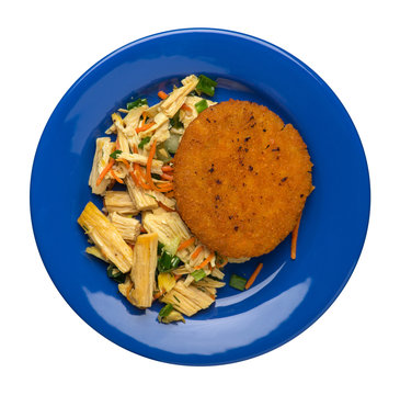 fishcake with soy asparagus and carrots, cucumbers and dilll. fish cutlet on a plate isolated. cutlet with vegetables top view