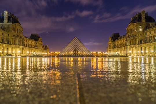iew of famous Louvre Museum with Louvre Pyramid at evening