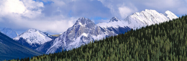 Canada, Alberta, Peter Lougheed PP. Jagged peaksare bound by a fir forest in Peter Lougheed PP, in Kananaskis Country, Alberta, Canada.