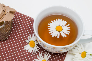 still life of tea cans and cups of tea with brown polka dots on a white table isolation top view place copy