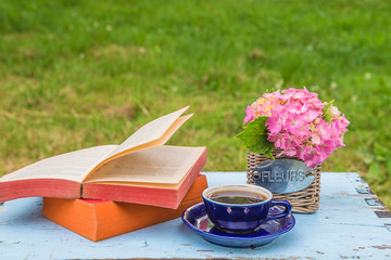 Naklejka na ściany i meble Vintage cup of coffee, open book and bouquet of hydrangea flowers in basket with text in french 