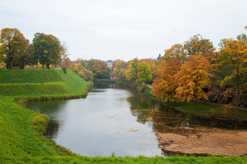 Fototapeta premium Copenhagen, Denmark - A river flows through the countryside. The reflection of trees on one side can be seen.