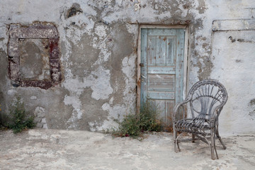 Fototapeta na wymiar Greece, Santorini. Old Building chair and doorway in town of Oia