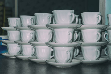 White coffee cups with saucers in stacks