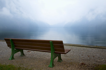 Naklejka na ściany i meble Germany, Lake Konigssee. Bench and lake in fog. 