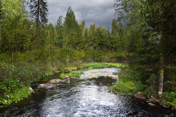 Storm clouds over the river and the forest