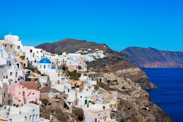 Fototapeta na wymiar White houses on the coast of Aegean Sea. Oia, Santorini Island, Greece.