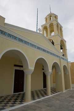 Greece, Santorini, Thira, Oia. Yellow facade and bell tower of Greek Orthodox church.