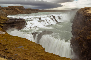 Fototapeta na wymiar Iceland, Gulfoss. Tourists view multiple waterfalls. Credit as: Cathy & Gordon Illg / Jaynes Gallery / DanitaDelimont.com