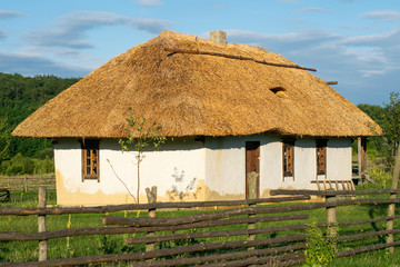 Fototapeta na wymiar Traditional Ukrainian house. Window and door in a wooden frame. Roof made of straw