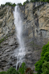 Fototapeta na wymiar High waterfall (Staubbach) falling from the tall cliff, Lauterbrunnen Switzerland
