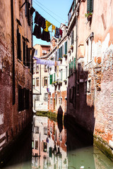 Murano, Venice, Italy. Canal. colored laundry, reflection, brick buildings