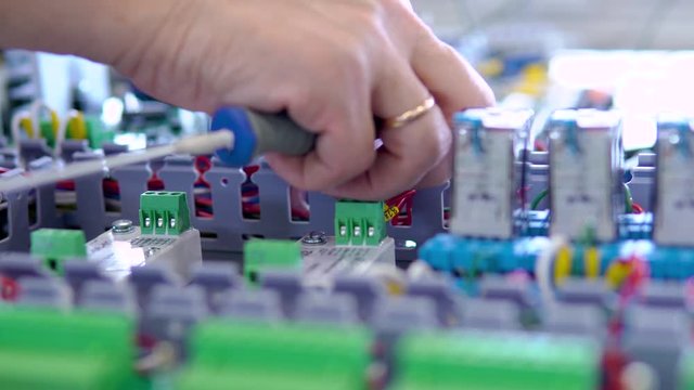 Electrician assembling industrial electric cabinet in workshop