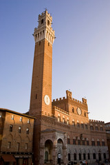 Fototapeta premium Italy, Tuscany, Sienna. Torre del Mangia on the Piazza del Campo at sunset.