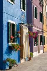 Fototapeta na wymiar Venice, Burano. A row of colorful homes along the canal.