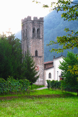 Fototapeta na wymiar Bagni di Lucca, Tuscany, Italy - Grass lawn leading up to an old world church in a rural area.
