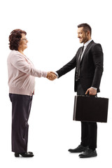 Fototapeta premium Senior woman shaking hands with a young businessman with a briefcase