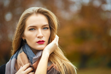 Glamor blonde girl wearing jacket, posing at the botanical garden