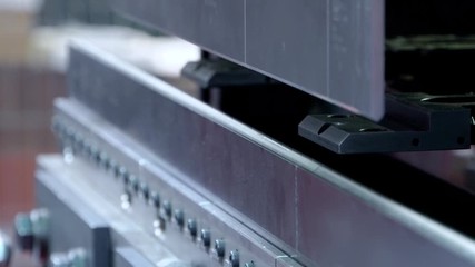 Worker operator bending metal sheet process by sheet bending machine for bus manufactuing part, steel folding with machine.