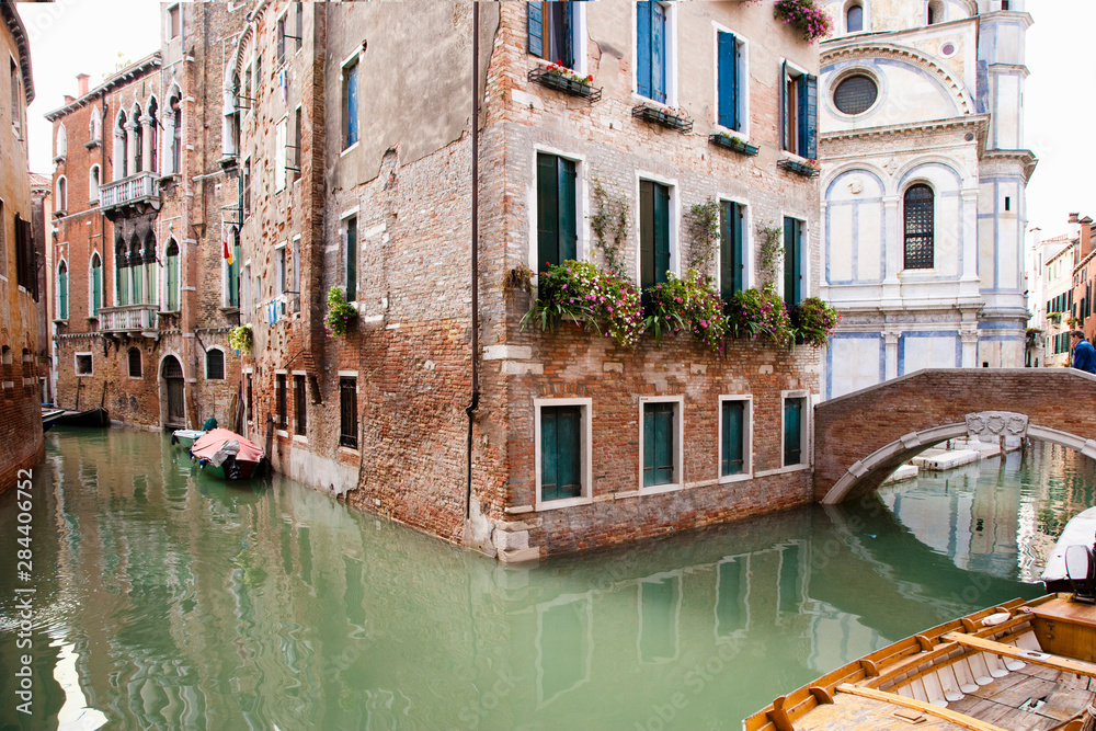 Wall mural venice, veneto, italy - buildings are surrounded by the canals in venice, italy. boats can be seen i