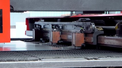 Rotation CNC punching & nibbling machine in action. Metal perforating industrial machine