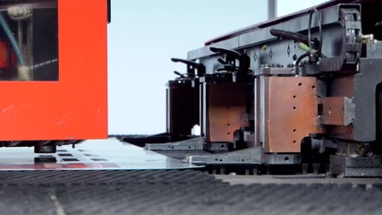 Rotation CNC punching & nibbling machine in action. Metal perforating industrial machine