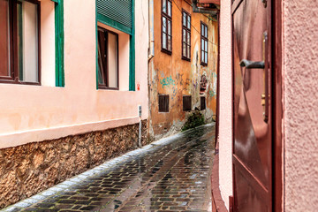 Romania. Brasov. Rain on narrow cobblestone passageway.