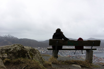 Fototapeta na wymiar Mujer sentada con vista en altura de la ciudad