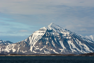 Norway. Svalbard. Spitsbergen. Forlandsundet. Snowy mountains tower over the water.