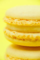 Two yellow macarons on yellow background