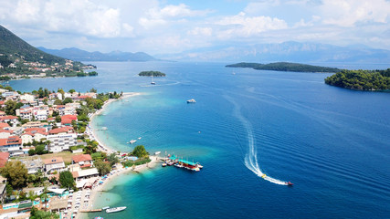 Fototapeta premium Aerial drone bird's eye view photo of iconic port of Nidri or Nydri a safe harbor for sail boats and famous for trips to Meganisi, Skorpios and other Ionian islands, Leflkada island, Ionian, Greece