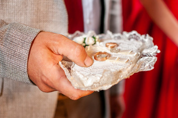 Gold wedding rings on the gold plate in the church