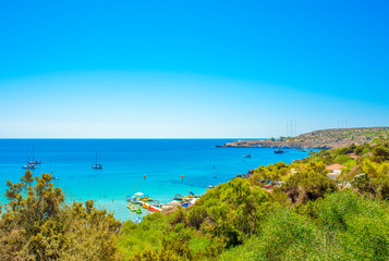  blue sea with clear water, mountains, yachts and the beach on the panorama of Konnos Bay Cyprus