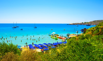  blue sea with clear water, mountains, yachts and the beach on the panorama of Konnos Bay Cyprus