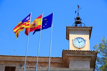 Spain, Balearic Islands, Mallorca. Palma de Mallorca, flags and clock tower.