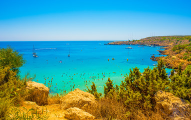  blue sea with clear water, mountains, yachts and the beach on the panorama of Konnos Bay Cyprus