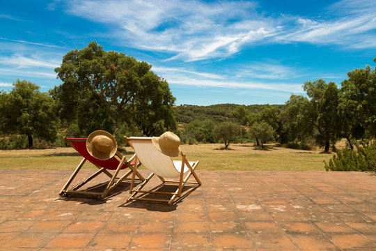 Dos hamacas, con un sombrero cada una, enfrente de un bosque de alcornoques en Alentejo, Portugal