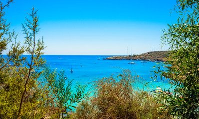  blue sea with clear water, mountains, yachts and the beach on the panorama of Konnos Bay Cyprus