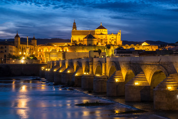 Spain, Andalusia. Cordoba. Roman bridge across the Guadalquivir river at dusk.