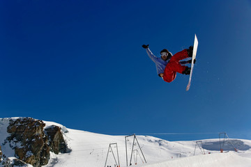 Snowboarder jumping in halfpipe, Klein Matterhorn, Zermatt, Switzerland.