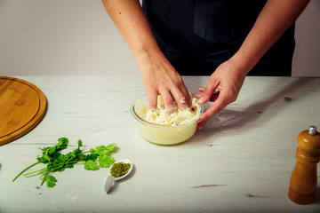 Female hands kneading dough on wooden table. cooking concept.