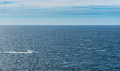 A white cabin cruiser crossing open seas.