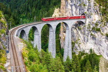 Papier Peint photo Viaduc de Landwasser Viaduc de Landwasser en Suisse. Train express Bernina sur pont de chemin de fer dans les montagnes. Vue panoramique sur le chemin de fer incroyable en été.