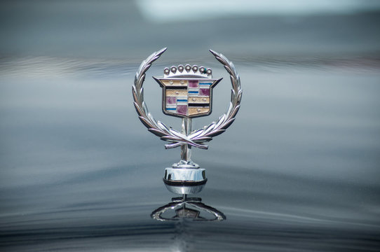 closeup of Cadillac logo on car front parked in the street