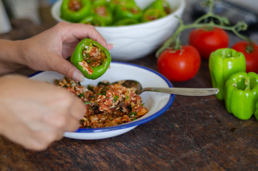 Woman is making stuffed pepper.