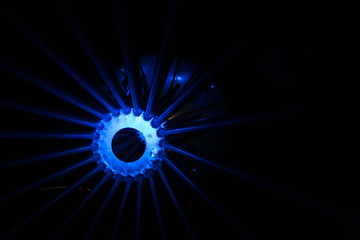 Glowing blue wheel with spokes radiating through the dark