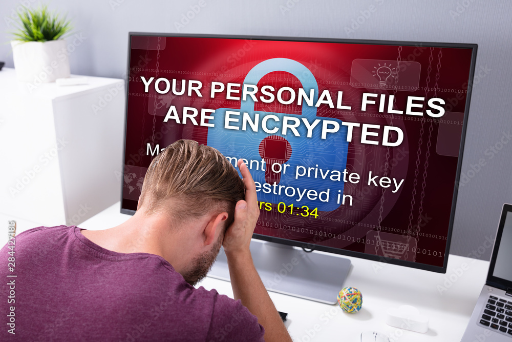 Poster worried man at computer with ransomware on the screen