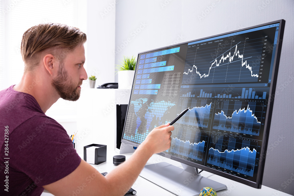 Poster businessman analyzing graph on computer