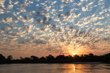 Naklejka na ściany i meble Brazil, The Pantanal, Rio Negro. Fluffy clouds dot the sky at sunset over the Rio Negro.