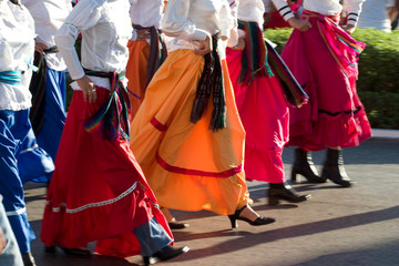 Mexico, Yucatan, Merida, dancers with swirling skirts in parade (lower torsos)